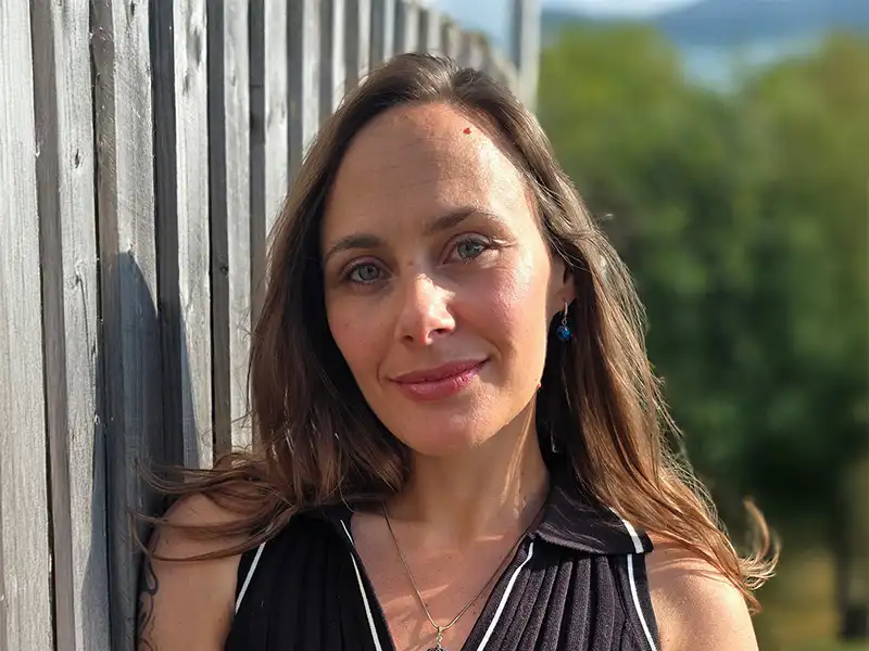 Man on the sofa with hi hand on his chest looking at his laptop