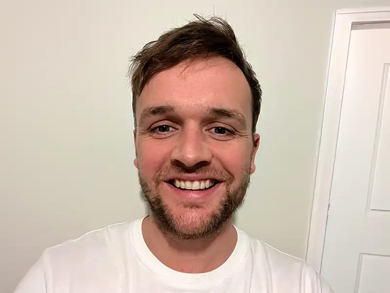 Man on the sofa with hi hand on his chest looking at his laptop Man on the sofa with hi hand on his chest looking at his laptop