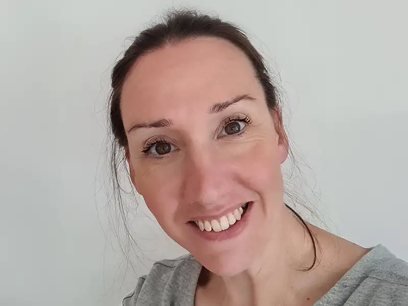 Man on the sofa with hi hand on his chest looking at his laptop